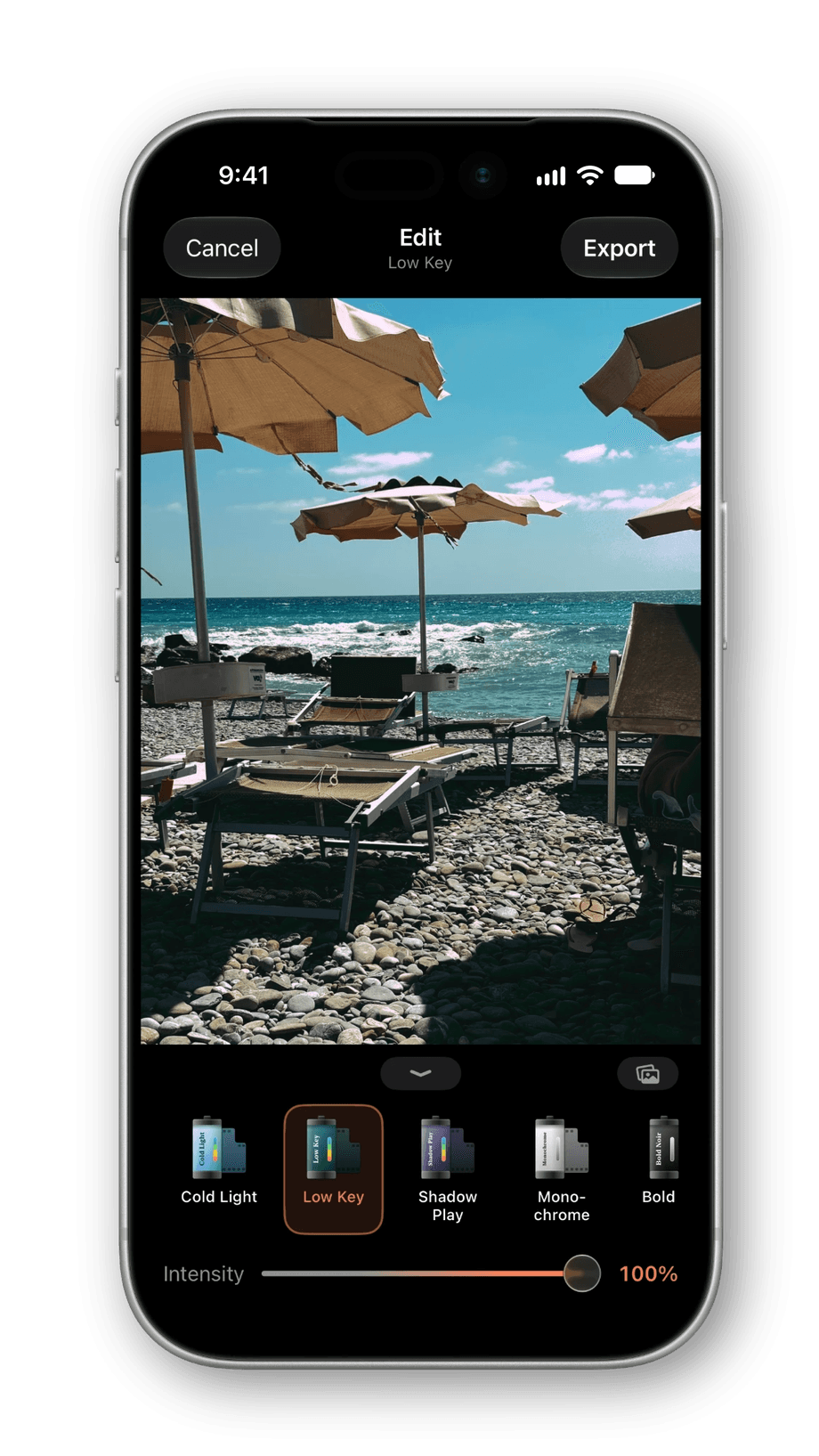 RAWCraft's Edit screen on an iPhone: a ProRAW photo of beach umbrellas and loungers with the Low Key look applied, a row of film cartridge looks beneath it, and the intensity slider at 100%